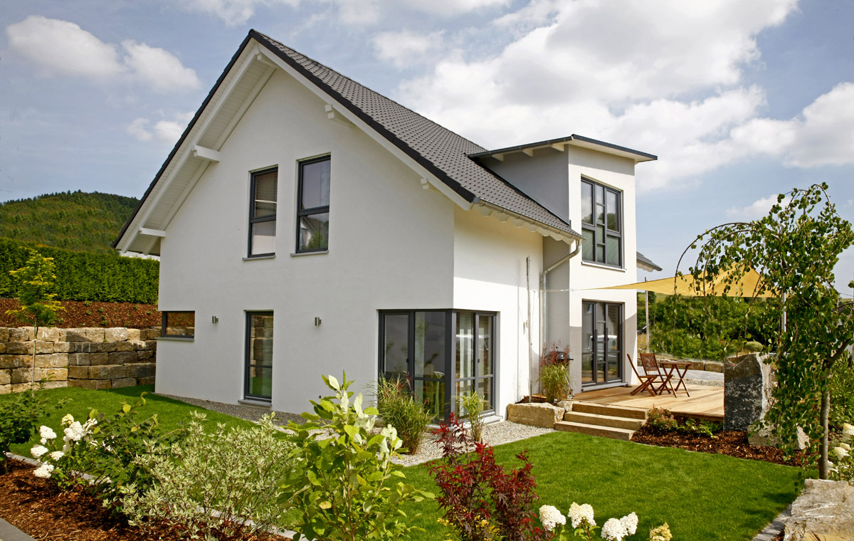 Partner-Haus Fertighaus mit Satteldach und Terrasse – Referenzhaus mit gepflegtem Garten und moderner Architektur